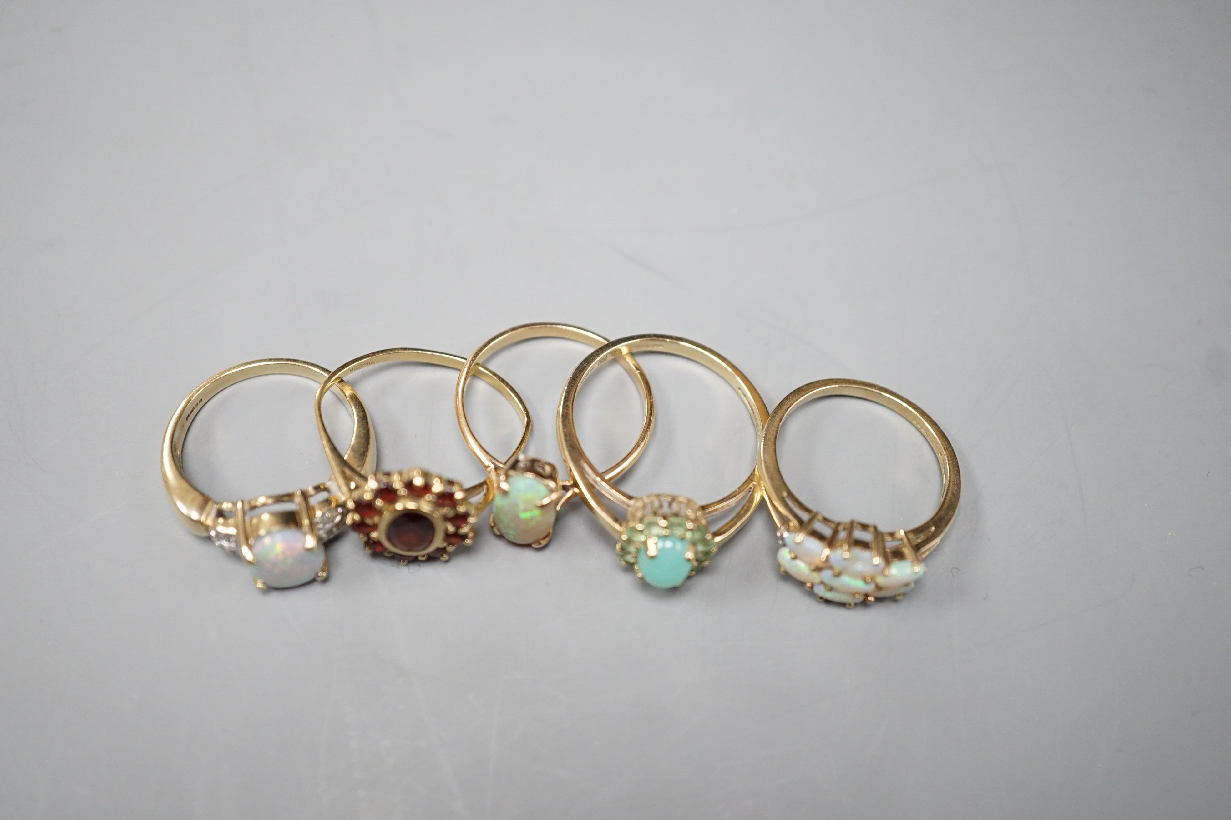 Five assorted modern 9ct gold and gem set dress rings, including white opal and diamond chip cluster, white opal cluster and garnet cluster